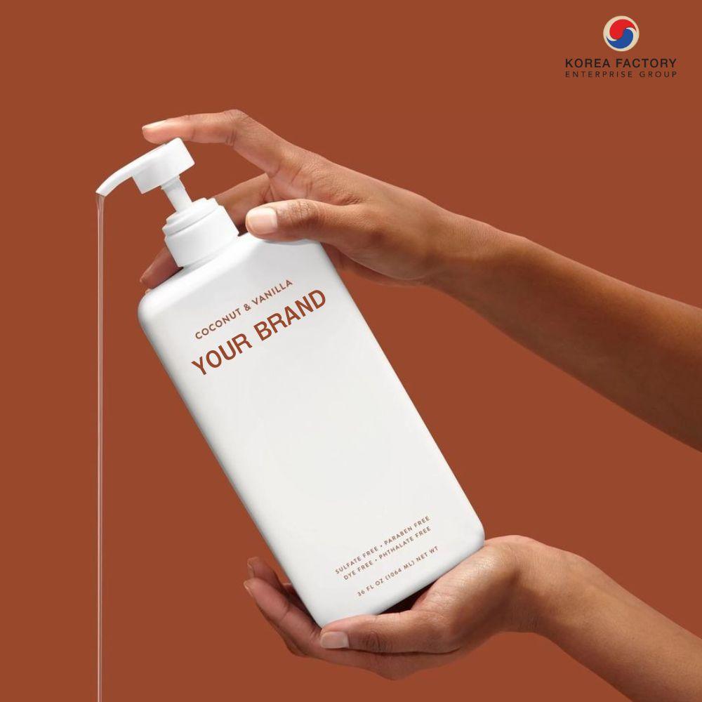 ขวดปั๊มสีขาวฉลาก YOUR BRAND อยู่ในมือผู้หญิง พื้นหลังสีน้ำตาล เจลอาบน้ำหรือโฟมอาบน้ำ พร้อมกรอบข้อความแนะนำโรงงานรับผลิตเจลอาบน้ำแบบ OEM ของ CosKorea Group