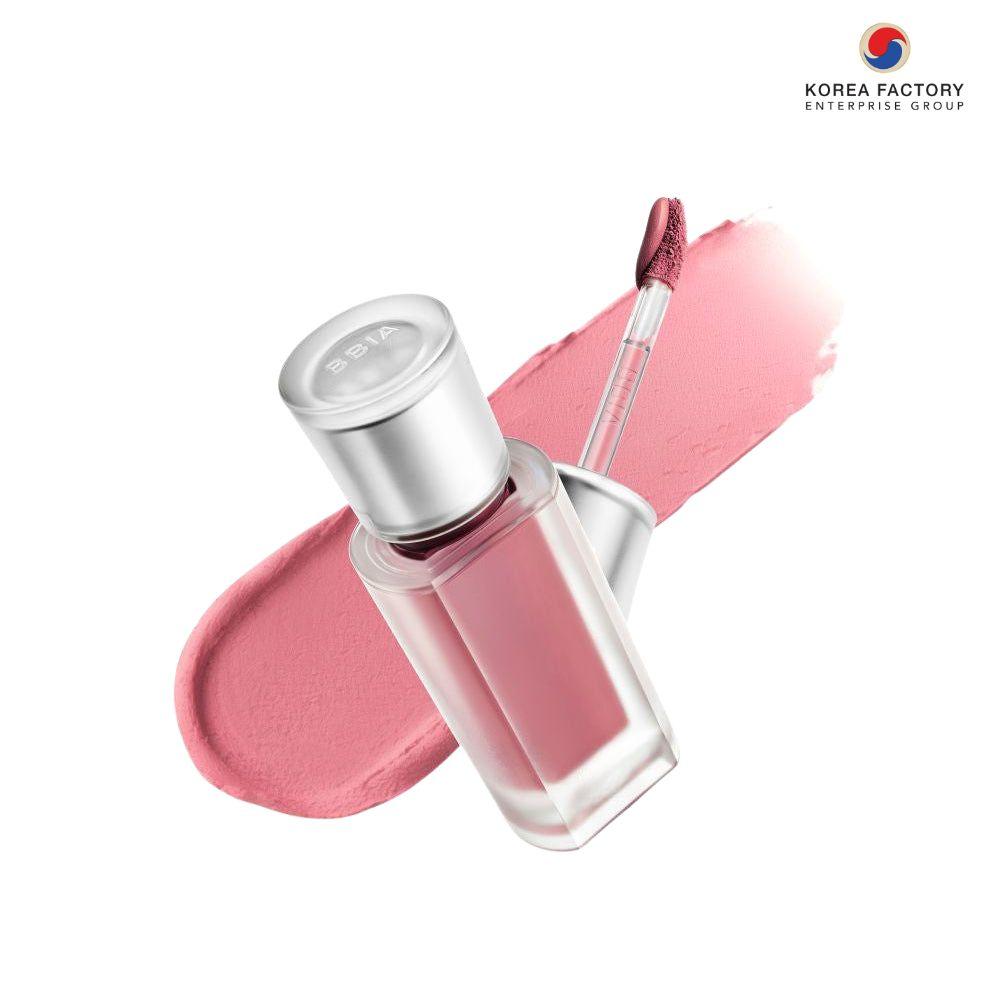 ลิปทินต์ขวดแก้วใสพร้อมแปรงจุ่ม วางบนสวอชลิปสีชมพูบนพื้นขาว และโลโก้ Korea Factory Enterprise Group